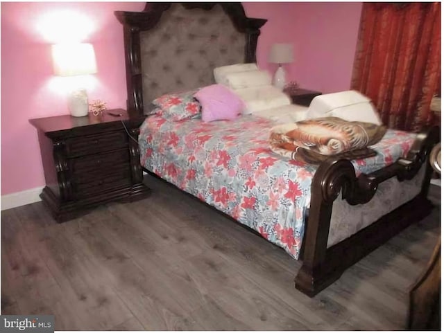 bedroom with dark wood-type flooring