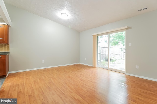 interior space featuring light wood-type flooring and a textured ceiling