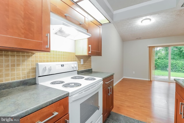 408 Berkshire Ct, Joppa, MD 21085 - kitchen with white range with electric cooktop, brown cabinets, a textured ceiling, under cabinet range hood, and backsplash