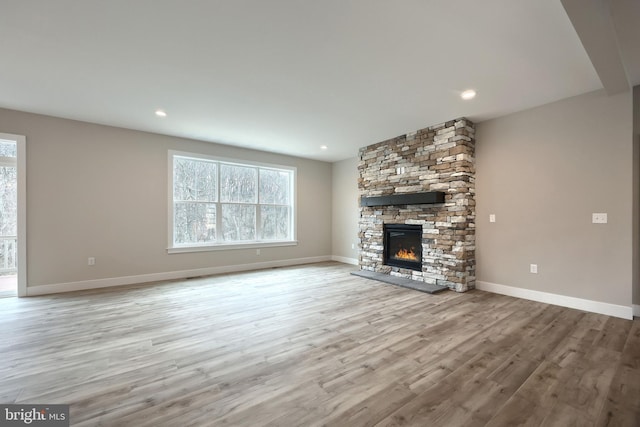 unfurnished living room featuring a fireplace and light hardwood / wood-style flooring