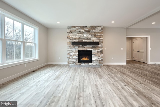 unfurnished living room with a healthy amount of sunlight, light wood-type flooring, and a fireplace