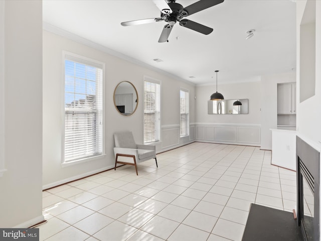 unfurnished room with ceiling fan, light tile patterned floors, a healthy amount of sunlight, and ornamental molding