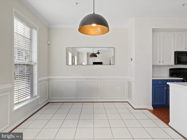 unfurnished dining area with ceiling fan and crown molding