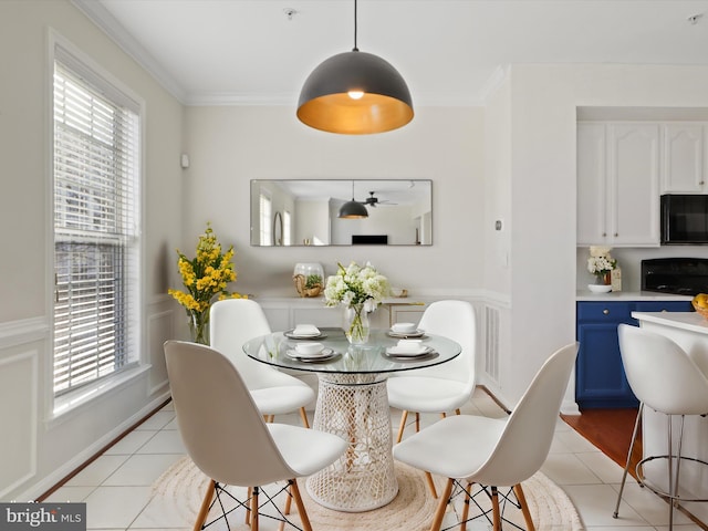 dining area featuring crown molding, light tile patterned floors, and ceiling fan