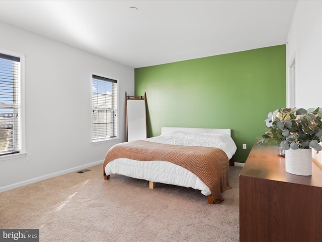 carpeted bedroom featuring multiple windows