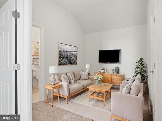 living room featuring carpet and vaulted ceiling