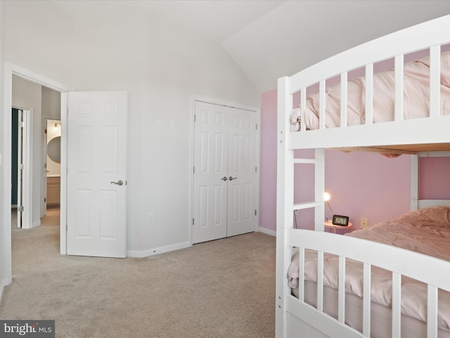 unfurnished bedroom with light colored carpet, lofted ceiling, and a closet