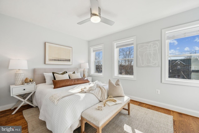 bedroom featuring wood finished floors, baseboards, and ceiling fan