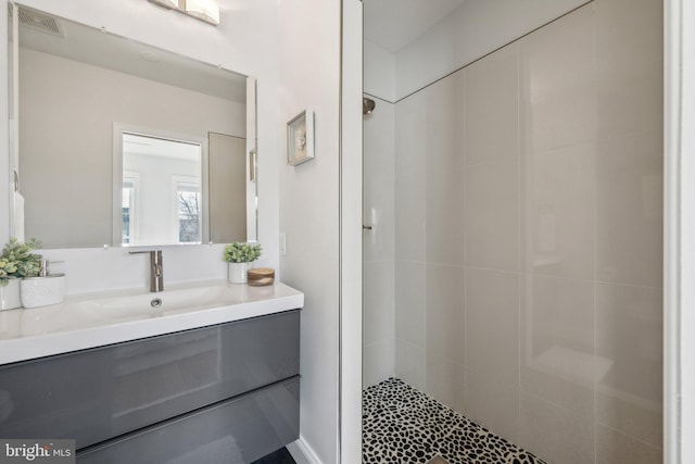 bathroom featuring vanity, visible vents, and a stall shower