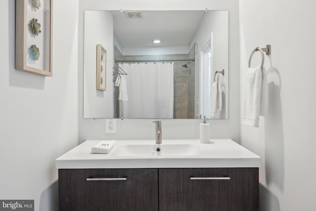 bathroom featuring vanity, a shower with shower curtain, and visible vents