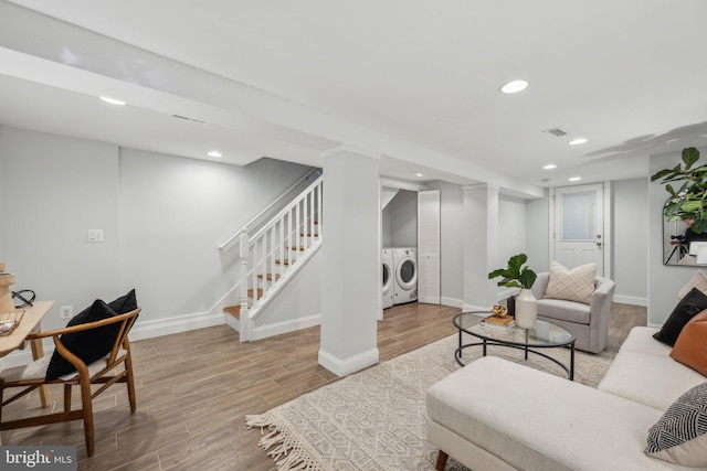 living area featuring washing machine and clothes dryer, stairway, recessed lighting, and wood finished floors