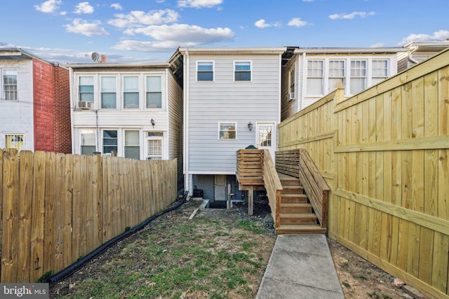 rear view of property featuring fence