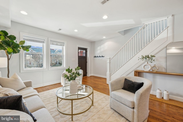 living room with stairs, recessed lighting, wood finished floors, and baseboards