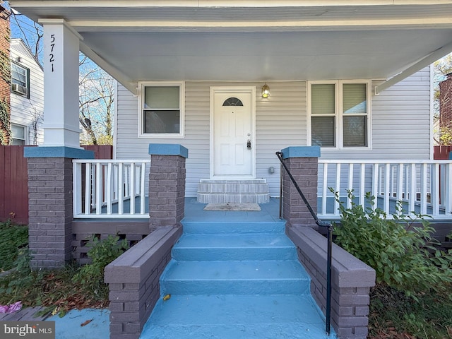 view of exterior entry featuring covered porch