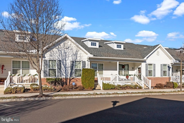 cape cod house featuring a porch