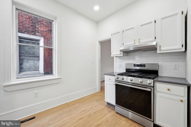 kitchen featuring backsplash, gas range, white cabinetry, and light hardwood / wood-style floors