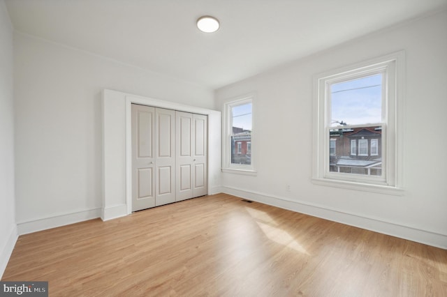 unfurnished bedroom featuring light wood-type flooring and a closet