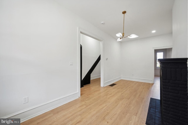 interior space featuring a notable chandelier and light wood-type flooring