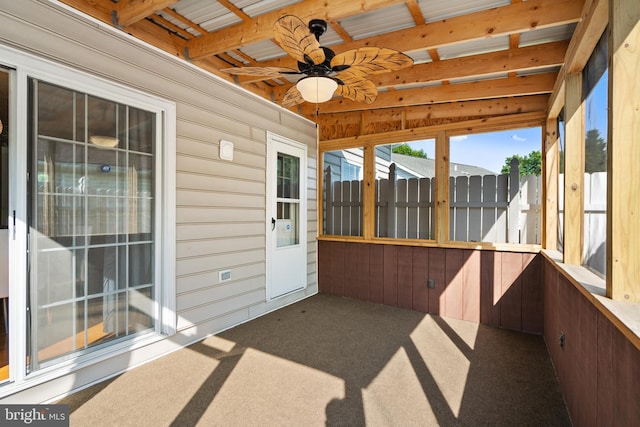 unfurnished sunroom with beam ceiling and ceiling fan