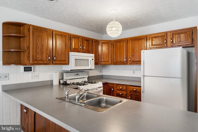 kitchen featuring white appliances, decorative light fixtures, tasteful backsplash, and sink