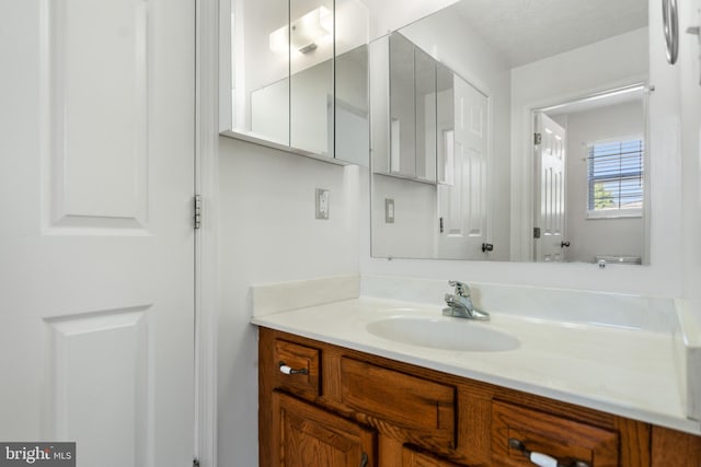 bathroom with vanity, toilet, and a textured ceiling