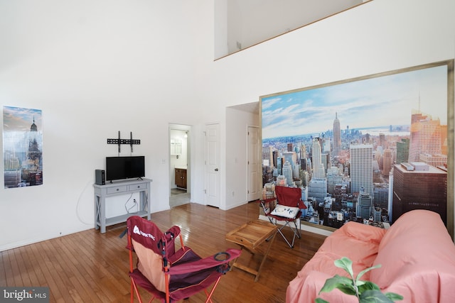 living room with dark hardwood / wood-style floors and a towering ceiling