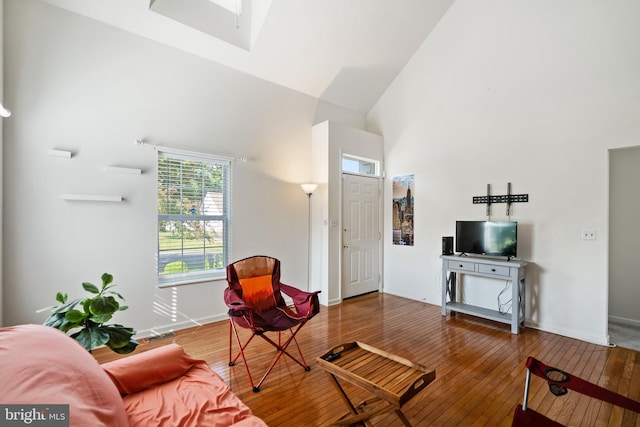 living room with wood-type flooring and a towering ceiling