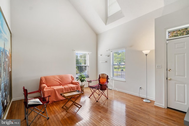 living area featuring a wealth of natural light, hardwood / wood-style floors, and high vaulted ceiling