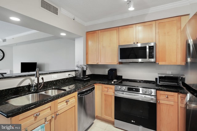 kitchen with dark stone counters, crown molding, sink, light brown cabinetry, and stainless steel appliances