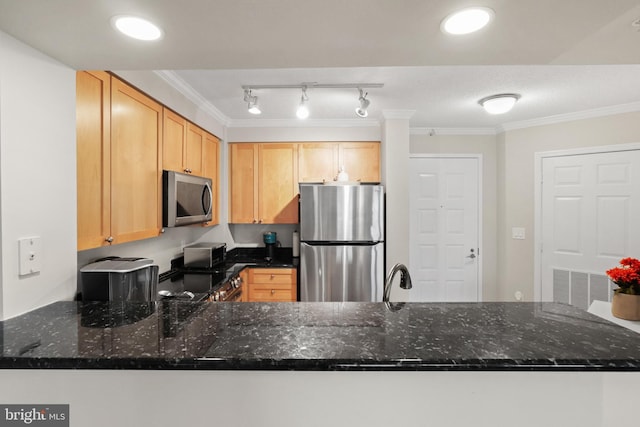 kitchen featuring dark stone countertops, kitchen peninsula, ornamental molding, and appliances with stainless steel finishes