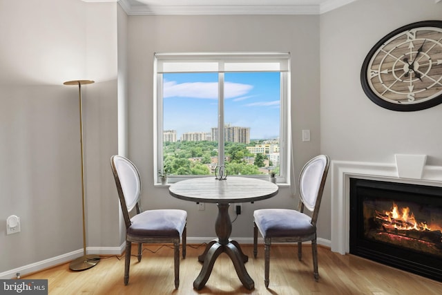 dining room with a wealth of natural light, light hardwood / wood-style floors, and ornamental molding