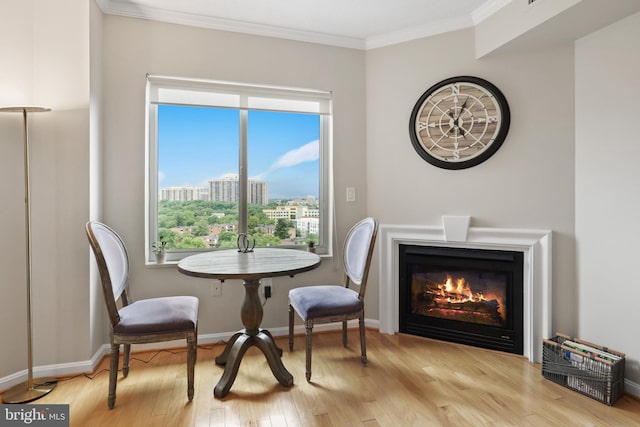 living area featuring light wood-type flooring and ornamental molding