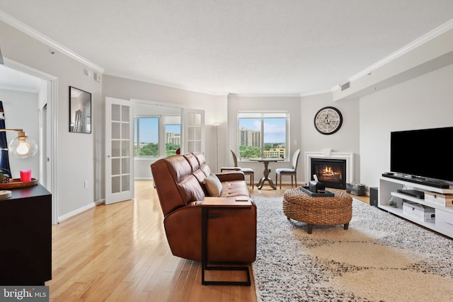 living room featuring light wood-type flooring, crown molding, and french doors