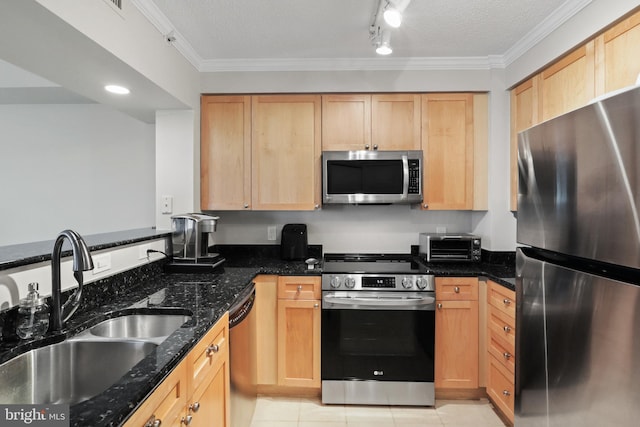 kitchen featuring appliances with stainless steel finishes, ornamental molding, a textured ceiling, sink, and dark stone countertops