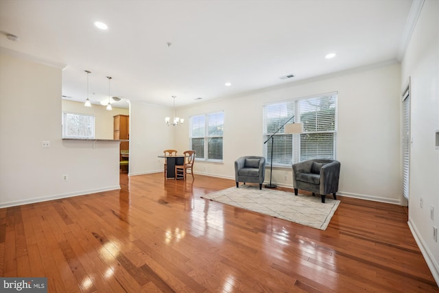 unfurnished room with an inviting chandelier, crown molding, and light hardwood / wood-style flooring