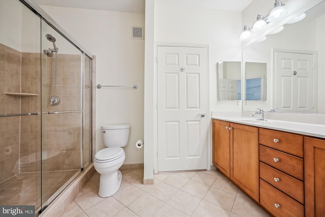 bathroom featuring an enclosed shower, vanity, toilet, and tile patterned floors