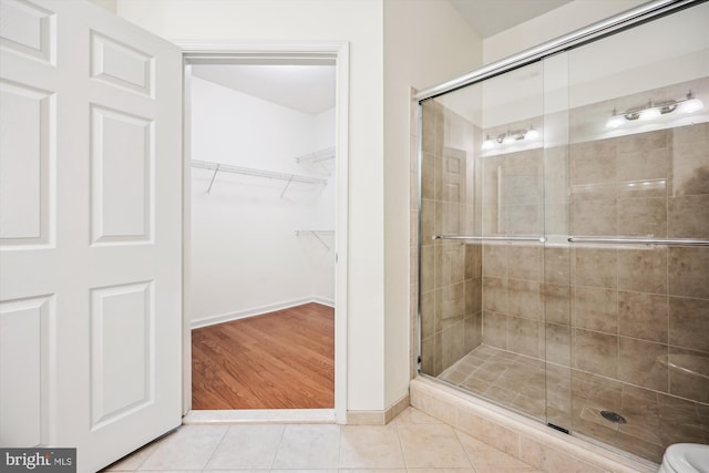 bathroom featuring hardwood / wood-style floors and a shower with shower door