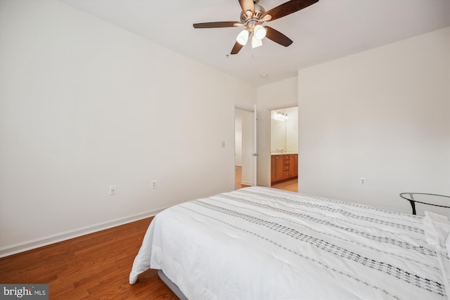 bedroom with hardwood / wood-style floors, ceiling fan, and ensuite bath