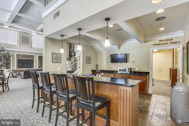 kitchen featuring a breakfast bar, dark carpet, coffered ceiling, crown molding, and beamed ceiling