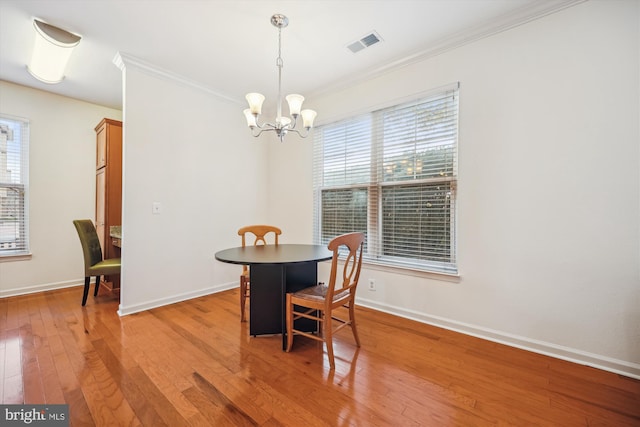 dining area featuring an inviting chandelier, light hardwood / wood-style floors, and ornamental molding