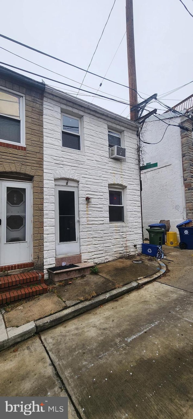 view of front of property with cooling unit and a patio