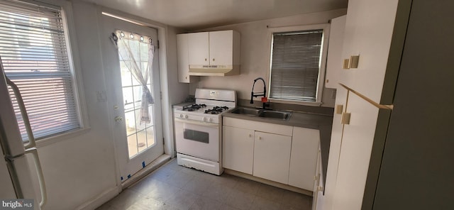 kitchen with white cabinetry, white gas range, and sink