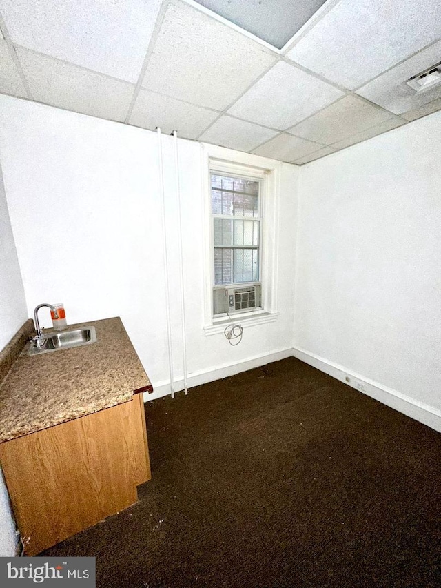 interior space with carpet, sink, cooling unit, and a drop ceiling