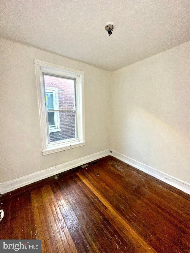 spare room featuring hardwood / wood-style floors and a textured ceiling