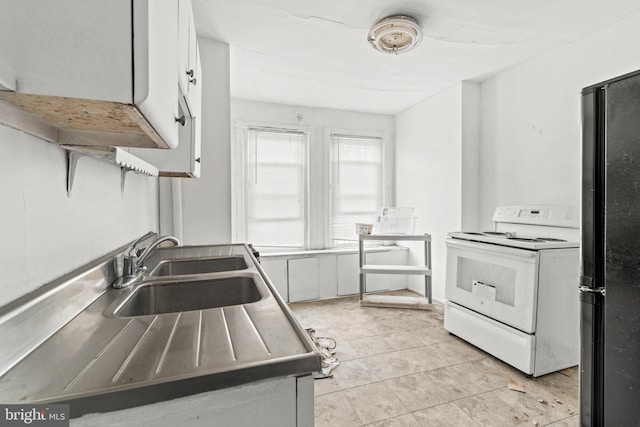 kitchen featuring white cabinets, black fridge, electric stove, and sink