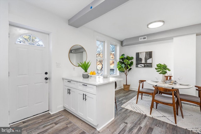 kitchen with dark hardwood / wood-style floors, white cabinetry, and plenty of natural light