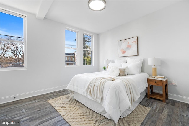 bedroom with beamed ceiling and dark hardwood / wood-style floors