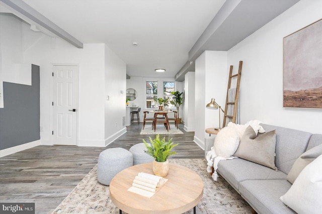 living room with hardwood / wood-style flooring and beam ceiling