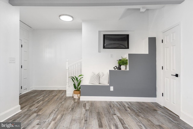 interior space with beam ceiling and wood-type flooring