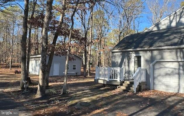 view of property exterior featuring a garage and a wooden deck